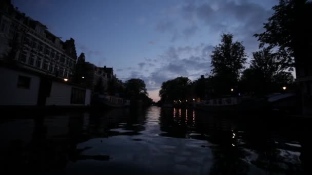 オランダ アムステルダムの夕暮れの都市運河の低角度の景色 — ストック動画