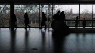 Havalimanı terminalinde siluet içinde büyük bir grup insan var..