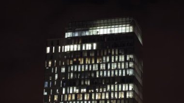 Amsterdam, Hollanda 'da geceleri pencereleri aydınlatılmış bir ofis binası. Zaman aşımı.