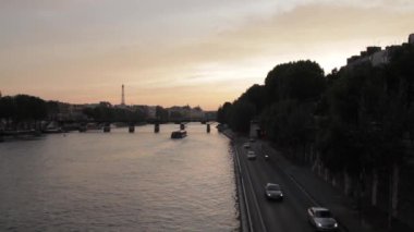 Paris, Fransa 'da gün batımında Seine nehri ve yol trafiği ve Eyfel Kulesi arka planda..