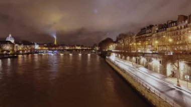 Seine Nehri ve nehir kenarındaki otobanın şehir manzarası. Fransa 'nın Paris şehrinde gece trafiğinin yol açtığı ışık yolları var. Zaman aşımı.