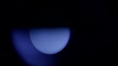 Siyah bir arkaplanda sönmüş bir ekranın mavi parıltıları parlıyor.