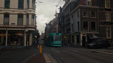 Amsterdam, Hollanda - 9 Ekim 2024: Tramvayı ve yerel trafiği olan Utrechtsestraat alışveriş caddesi ve yürüyen insanlar.