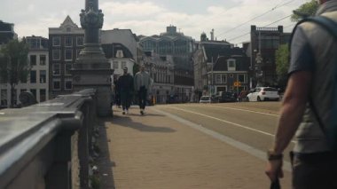 Amsterdam, Hollanda - 20 Mayıs 2023: Şehir merkezinde bisiklet süren insanlarla birlikte şehir sokak manzarası.