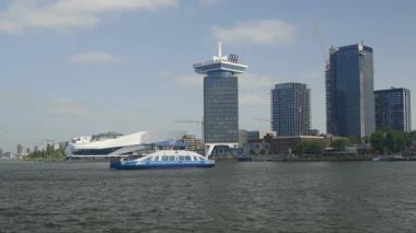 Amsterdam, Hollanda - 26 Mayıs 2023: Amsterdam Merkez İstasyonu feribot teknesi ve ADAM Gözcü Kulesi.