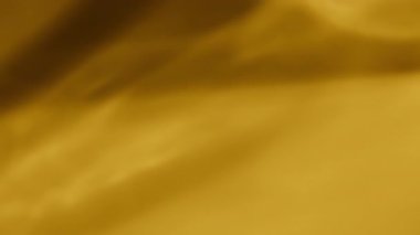 Arkaplanda dönen cam nesnelerin soyut sarı ışık yansıması.