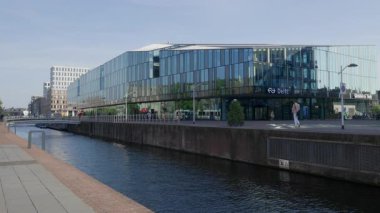 Hollanda, Delft 'teki modern mimari cam ön cephe tren istasyonuna sahip şehir kanalı..