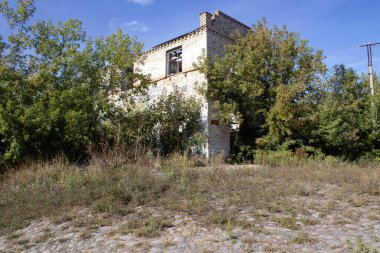  Ukrayna 'daki bir köyde eski bir bina. Daha önce sanayi olarak kullanılan eski bir ev. Ve şimdi kimsenin ona ihtiyacı yok, duruyor ve çürüyor. Ağaçlar ve çalılar yetişiyor, çatı. .