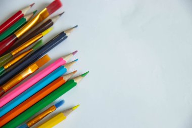 Çizim için renkli kalem ve fırçaların çok renkli arkaplanı. Eğitim kurumlarındaki çeşitli öğrenciler için eğitim malzemeleri. Bilgi Günü için şenlikli arkaplan.