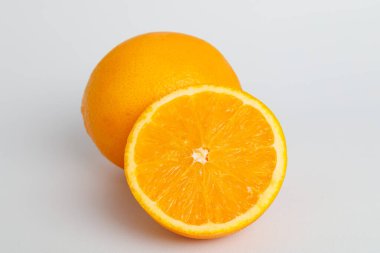 Olgun ve yarım portakal meyvesi beyaz arka planda izole edilmiş Kırpma Yolu