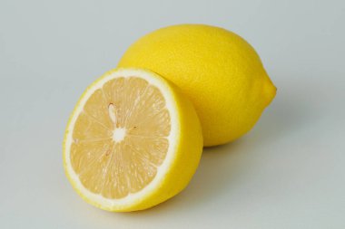 Yarı soyutlanmış limon meyvesi. Beyaz arka planda tam limon ve yarım limon. Limonlar izole edilmiş. Kırpma yolu ile. Tam alan derinliği.