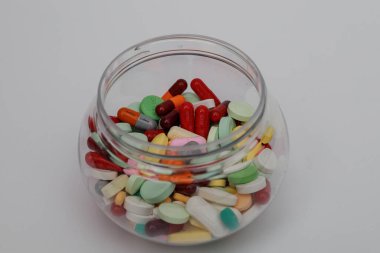 Şeffaf bir kasede bir yığın ilaç. Üst Manzara. Çok fazla ilaç. Kimyasal tedaviyi durdurma kampanyası. Bitkisel ilaçlara başlama zamanı. beyaz arkaplanda izole.