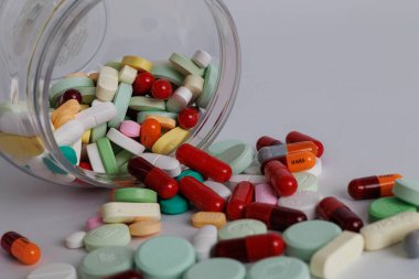 Beyaz arka planda ilaç konteynerlerinden çeşitli kimyasal ilaçlar dökülmüş. Yakın plan. Seçici odaklanma. Kapat.. 