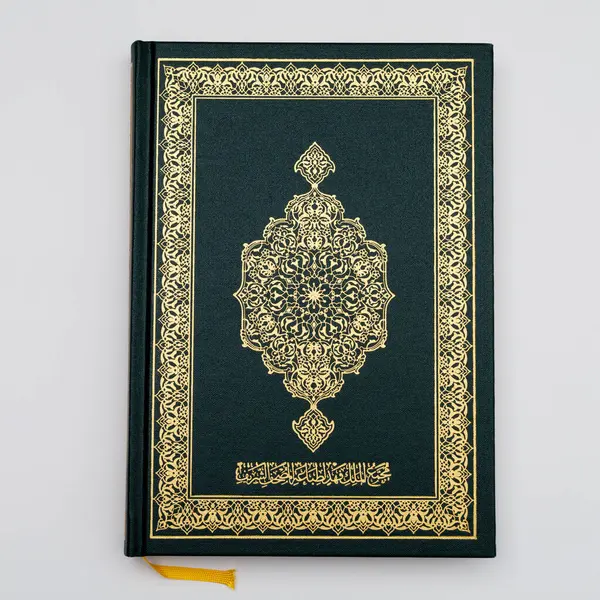 Medine 'de beyaz bir arka planda izole edilmiş, orta büyüklükte, orijinal yeşil bir Kur' an. en üstteki görünüm.