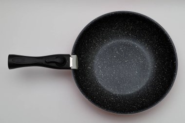 Beyaz arka planlı kırmızı seramiklerden yapılmış tava. Uzun ömürlü tava. Yapışmayan tava. Yağsız kızarma.