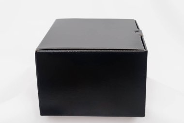 Beyaz arka planda siyah karton kutu. Yan görünüm.