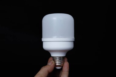 Siyah arkaplanda izole edilmiş, el ele tutuşan ampulün yakın çekimi