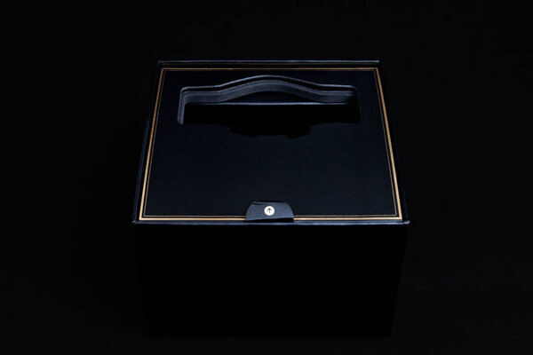 Empty elegant black smartwatch box with gold strip on black background. Top view, flat lay..
