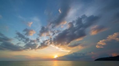 Karon plajı Phuket Tayland 'da gün batımında okyanus bulutlarının üzerindeki günbatımı manzarası okyanusu kaplıyor. video 4K. Gökyüzü arka planında Renkli Kırmızı Işık Sahnesi.