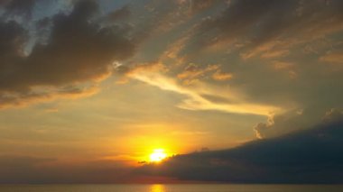 Karon plajı Phuket Tayland 'da gün batımında okyanus bulutlarının üzerindeki günbatımı manzarası okyanusu kaplıyor. video 4K. Gökyüzü arka planında Renkli Kırmızı Işık Sahnesi.