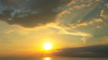 Karon plajı Phuket Tayland 'da gün batımında okyanus bulutlarının üzerindeki günbatımı manzarası okyanusu kaplıyor. video 4K. Gökyüzü arka planında Renkli Kırmızı Işık Sahnesi.