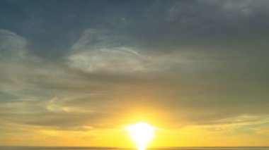Karon plajı Phuket Tayland 'da gün batımında okyanus bulutlarının üzerindeki günbatımı manzarası okyanusu kaplıyor. video 4K. Gökyüzü arka planında Renkli Kırmızı Işık Sahnesi.