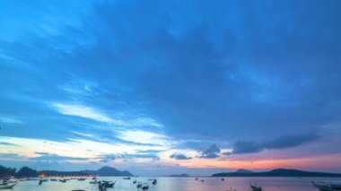 Karon plajı Phuket Tayland 'da gün batımında okyanus bulutlarının üzerindeki günbatımı manzarası okyanusu kaplıyor. video 4K. Gökyüzü arka planında Renkli Kırmızı Işık Sahnesi.