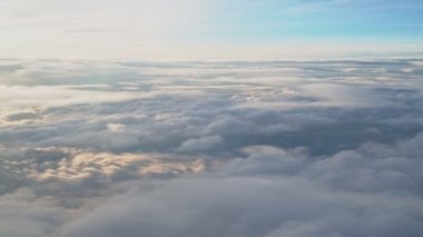 Bir uçağın penceresinden bak. Katmanlar halinde yüzen beyaz bulutlar inanılmaz güzel görünüyor. Bulutların güzelliği..