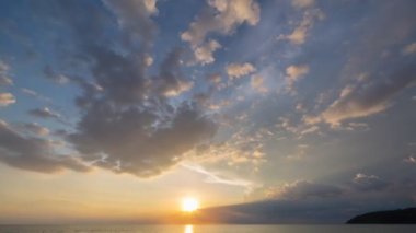 Zaman su üstünde büyük bir bulut altın gün batımına doğru ilerliyor. Deniz üzerinde güneşli bir akşam manzarası. Horizon Panorama dramatik alacakaranlık gökyüzü ve bulutlu günbatımı arkaplanı. Doğa video görüntüleri..