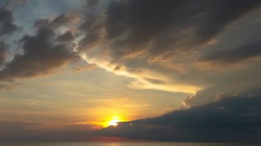 Zaman su üstünde büyük bir bulut altın gün batımına doğru ilerliyor. Deniz üzerinde güneşli bir akşam manzarası. Horizon Panorama dramatik alacakaranlık gökyüzü ve bulutlu günbatımı arkaplanı. Doğa video görüntüleri..