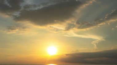 Zaman su üstünde büyük bir bulut altın gün batımına doğru ilerliyor. Deniz üzerinde güneşli bir akşam manzarası. Horizon Panorama dramatik alacakaranlık gökyüzü ve bulutlu günbatımı arkaplanı. Doğa video görüntüleri..