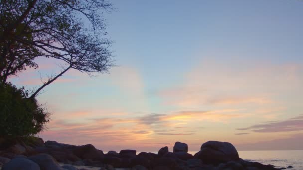 岩の夕日の風景空 グラデーションの色 空のテクスチャ抽象的な自然背景 岩のビーチの背後に夕日の空を通して光 甘い色の光線やその他の大気の影響 — ストック動画