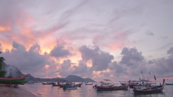 午前中の美しいシンプルな自然の生活 太陽が浮かぶ雲のピークの上に輝きます ベイに並んで漁船 — ストック動画