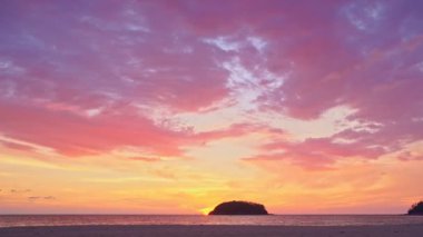 Akşamları adanın yukarısında gökyüzünde renkli bulutlar. Sarı güneş renkli gökyüzünde Kata plajı Phuketi 'ndeki Pu adasının arkasında batıyor. Adanın arka planında mor bulutlar..