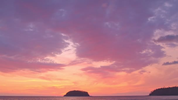 夜は島の上空のカラフルな雲 カタビーチの浦島の裏側に沈む黄色い太陽 島の背景の上の紫色の雲 — ストック動画