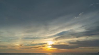 Karon plajı Phuket Tayland 'da gün batımında okyanus bulutlarının üzerindeki günbatımı manzarası okyanusu kaplıyor. video 4K. Gökyüzü arka planında Renkli Kırmızı Işık Sahnesi.
