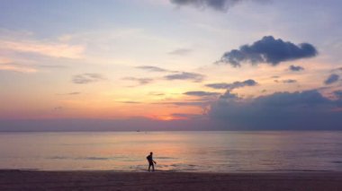 Okyanus bulutlarının üzerindeki hava manzaralı gün batımı Karon sahilindeki Phuket Tayland 'da gün batımında okyanusu kaplıyor. video 4K. Gökyüzünde tatlı sarı ışık manzarası.