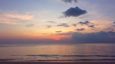 Okyanus bulutlarının üzerindeki hava manzaralı gün batımı Karon sahilindeki Phuket Tayland 'da gün batımında okyanusu kaplıyor. video 4K. Gökyüzünde tatlı sarı ışık manzarası.