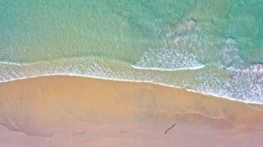 Hava üst görüntüsü dalga dalga sahile doğru sürüklendi. Sahilde turkuaz deniz kumu manzarası ve yaz günü el sallama. Sahildeki deniz alanı. Mavi deniz, Kata Beach Phuket Thai 'de dalgalar çarpışıyor.