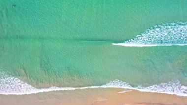 Hava üst görüntüsü dalga dalga sahile doğru sürüklendi. Sahilde turkuaz deniz kumu manzarası ve yaz günü el sallama. Sahildeki deniz alanı. Mavi deniz, Kata Beach Phuket Thai 'de dalgalar çarpışıyor.