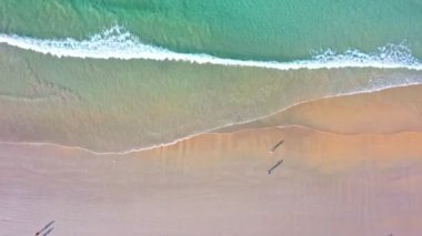 Hava üst görüntüsü dalga dalga sahile doğru sürüklendi. Sahilde turkuaz deniz kumu manzarası ve yaz günü el sallama. Sahildeki deniz alanı. Mavi deniz, Kata Beach Phuket Thai 'de dalgalar çarpışıyor.