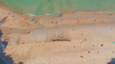 aerial view blue sea white sand beach at Niharn beach.Nai Harn beach is a famous landmark and popular sunset viewpoint of Phuket Thailand.smooth waves hit on white sand beach.