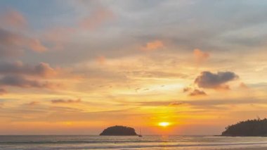 timelapse colorful bright sky of sunset behind lifeguard tower at Karon beach.Karon beach is broad and long Sand and beautiful beach.4k stock footage video in travel concept. bright sky background