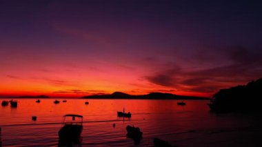 aerial view beautiful sunrise above fishing boats It creates a beautiful reflection in the water.scenic reflection of beautiful sunshine in the sea fishing boats are floating in the sea of Phuketbeautiful sunrise background.