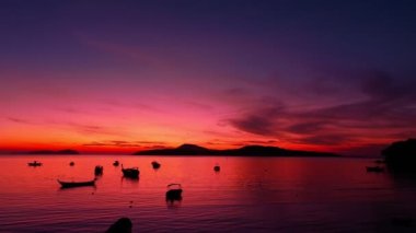 aerial view beautiful sunrise above fishing boats It creates a beautiful reflection in the water.scenic reflection of beautiful sunshine in the sea fishing boats are floating in the sea of Phuketbeautiful sunrise background.