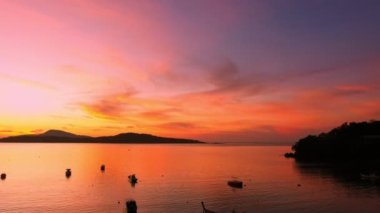 aerial view beautiful sunrise above fishing boats It creates a beautiful reflection in the water.scenic reflection of beautiful sunshine in the sea fishing boats are floating in the sea of Phuketbeautiful sunrise background.
