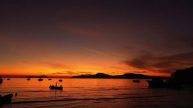 aerial view beautiful sunrise above fishing boats It creates a beautiful reflection in the water.scenic reflection of beautiful sunshine in the sea fishing boats are floating in the sea of Phuketbeautiful sunrise background.