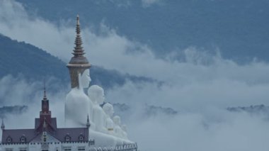 Big White Five buddha Statues in Wat Phra That Pha Son Kaew temple at Phetchabun Thailandbeautiful and famous landmark in Thailand. sea of mist background. 