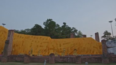 beautiful reclining Buddha at Wat Khun Inthapramun is temple that built in Sukhothai erea. It's exquisite and ancient. The temple is ruin but the Buddha is completely perfect.robe cloth background.