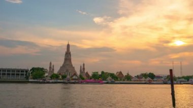time lapse scenery sunset at large illuminated temple Wat Arun ratchawararam the biggest and tallest pagoda in the world beside Chaophraya river Bangkok Thailand.reflection of beautiful pagoda.